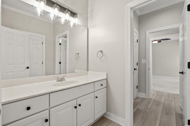 bathroom with crown molding, vanity, and wood finished floors