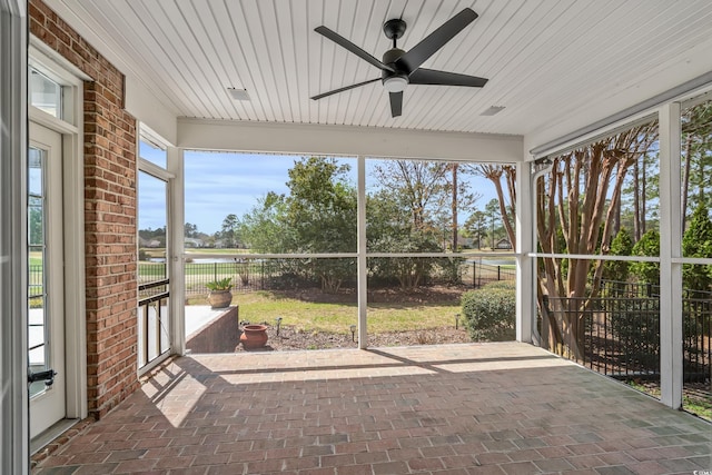 unfurnished sunroom with a ceiling fan
