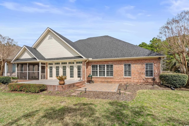 back of house with a sunroom, brick siding, a shingled roof, and a patio area