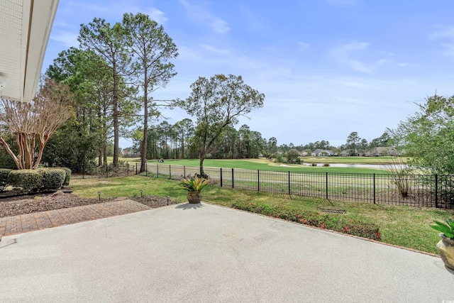 view of patio / terrace with a water view, view of golf course, and a fenced backyard
