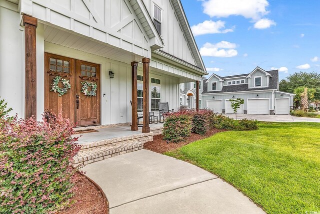 entrance to property featuring covered porch, board and batten siding, concrete driveway, and a lawn