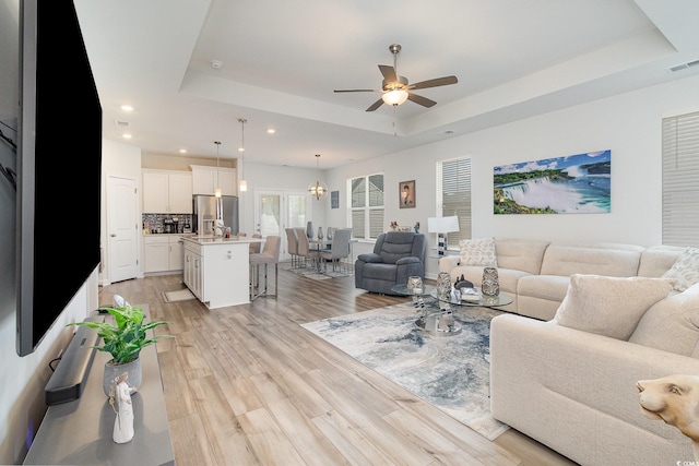 294 Portofino Dr, Myrtle Beach, SC 29579 - living room featuring a tray ceiling, recessed lighting, light wood finished floors, and a ceiling fan