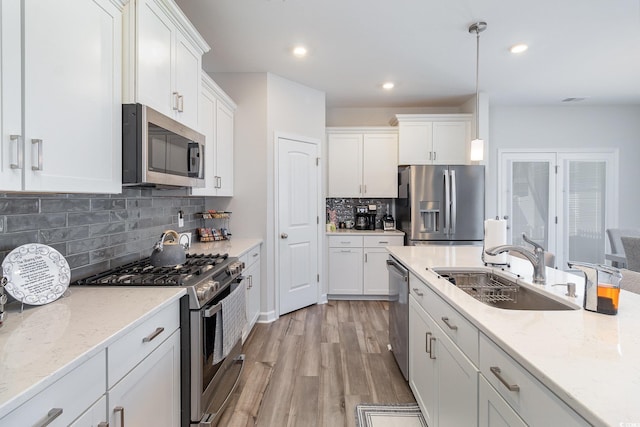 294 Portofino Dr, Myrtle Beach, SC 29579 - kitchen with appliances with stainless steel finishes, white cabinetry, light wood-type flooring, decorative backsplash, and recessed lighting