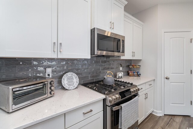 294 Portofino Dr, Myrtle Beach, SC 29579 - kitchen featuring stainless steel appliances, backsplash, white cabinets, and light stone countertops