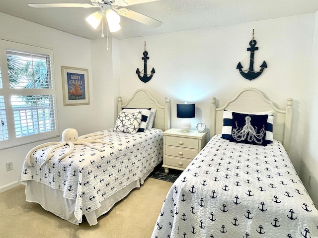 bedroom featuring light colored carpet, baseboards, and ceiling fan