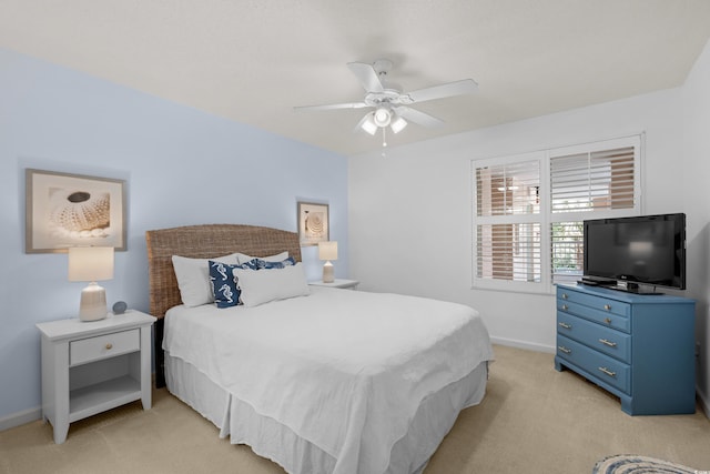 bedroom featuring baseboards, light colored carpet, and ceiling fan