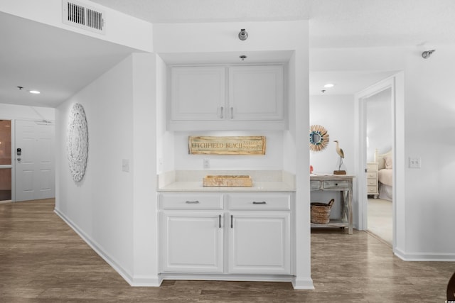 corridor with visible vents, recessed lighting, baseboards, and wood finished floors