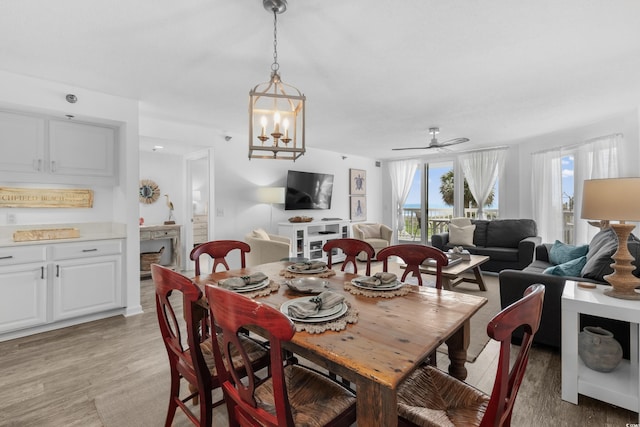 dining space with ceiling fan, a fireplace, light wood-style flooring, and a wealth of natural light