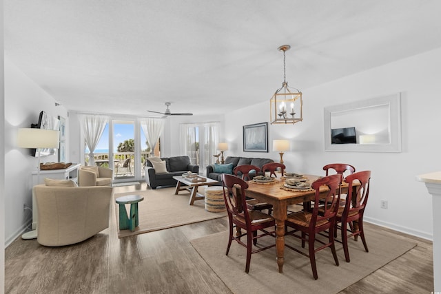 dining area featuring an inviting chandelier, baseboards, and wood finished floors