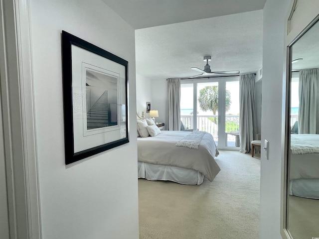 carpeted bedroom featuring a textured ceiling, ceiling fan, and access to exterior