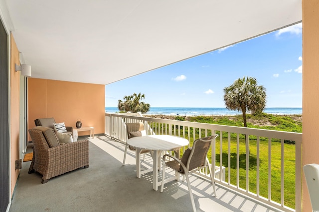 balcony with a water view and a view of the beach