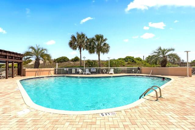 pool with fence and a patio area
