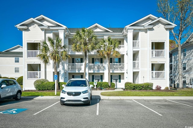view of property with central AC and uncovered parking