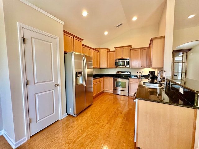 1612 Fairforest Ct, Conway, SC 29526 - kitchen featuring stainless steel appliances, arched walkways, light wood-style floors, dark stone counters, and vaulted ceiling