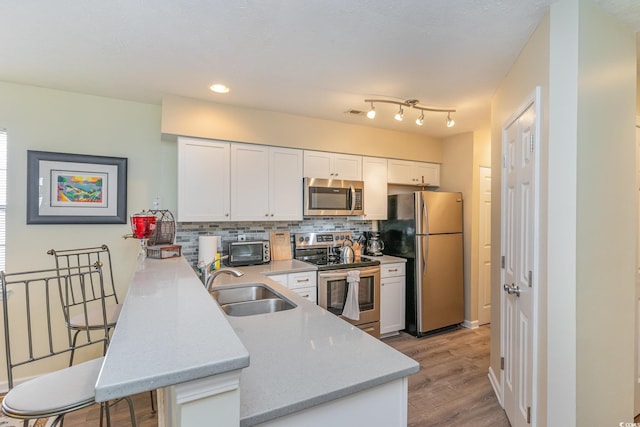 478 Pinehurst Ln Unit 17D, Pawleys Island, SC 29585 - kitchen featuring appliances with stainless steel finishes, a sink, a peninsula, white cabinetry, and decorative backsplash