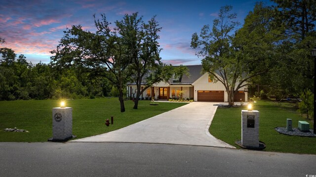 view of front of house with a lawn, a garage, and concrete driveway