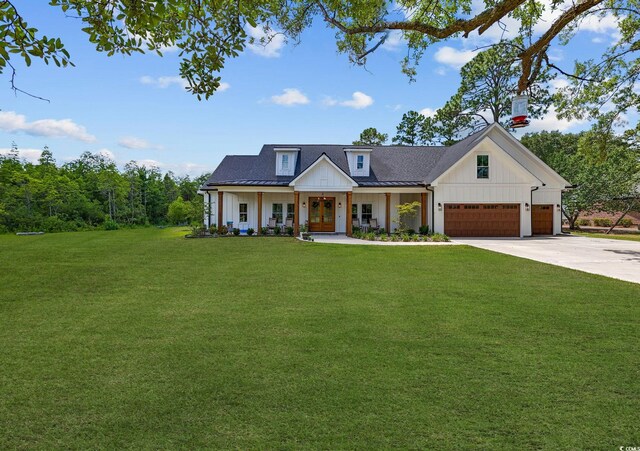 modern inspired farmhouse with a garage, a front yard, board and batten siding, driveway, and french doors