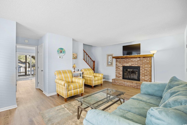 600-B 43rd Ave S, North Myrtle Beach, SC 29582 - living room with wood finished floors, stairway, a textured ceiling, and a brick fireplace