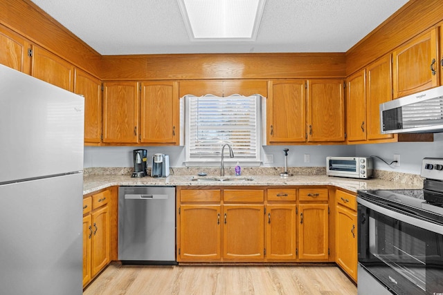 600-B 43rd Ave S, North Myrtle Beach, SC 29582 - kitchen featuring appliances with stainless steel finishes, light wood-style flooring, and brown cabinetry