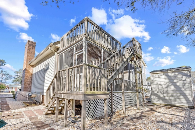 600-B 43rd Ave S, North Myrtle Beach, SC 29582 - back of house with stairs, a sunroom, a chimney, and a wooden deck