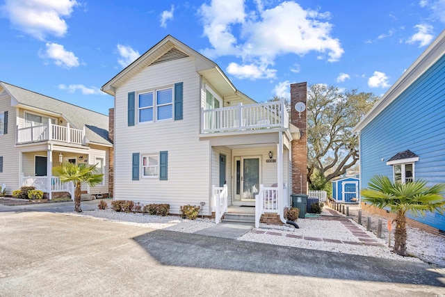 600-B 43rd Ave S, North Myrtle Beach, SC 29582 - view of front of property with a balcony, a storage shed, a chimney, and a porch