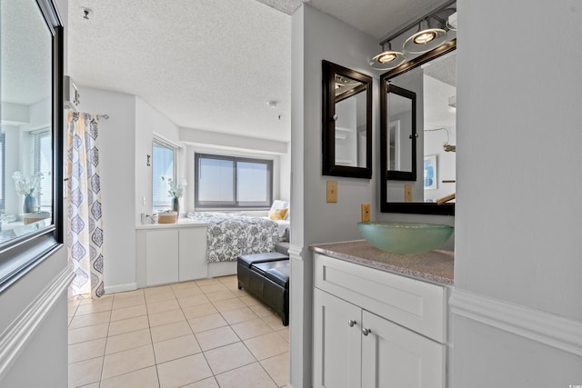 full bath featuring vanity, tile patterned flooring, a textured ceiling, and a wealth of natural light