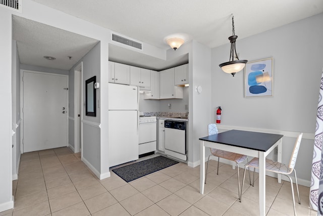 kitchen with white appliances, white cabinets, visible vents, and light countertops