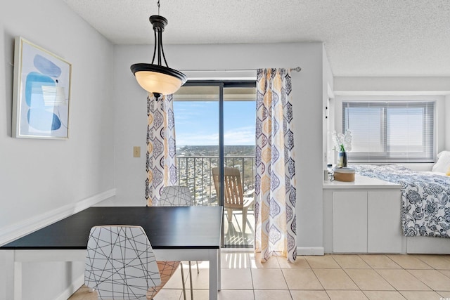 tiled dining room with baseboards, a textured ceiling, and a wealth of natural light