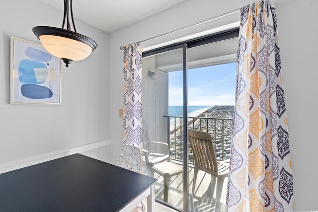 dining space featuring a water view and a view of the beach