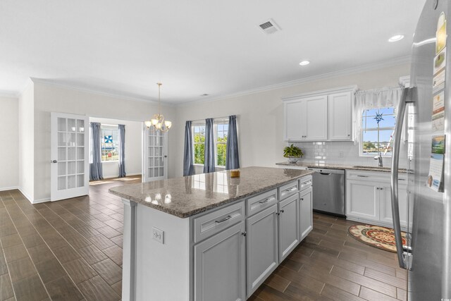 100 Marblehead Dr, Little River, SC 29566 - kitchen with appliances with stainless steel finishes, wood finish floors, a kitchen island, a chandelier, and white cabinets