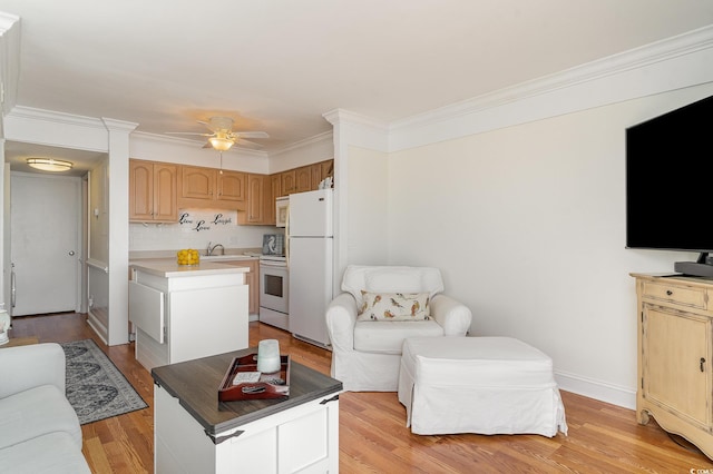 living room featuring baseboards, light wood-style flooring, ornamental molding, and a ceiling fan