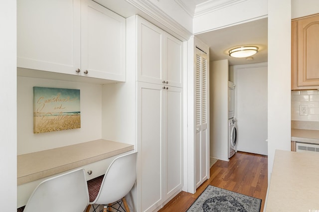 home office with stacked washer and dryer, built in study area, and light wood-type flooring