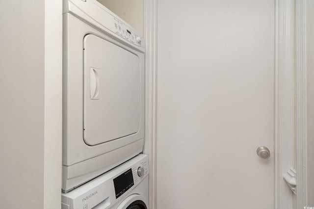 clothes washing area with stacked washer / dryer and laundry area