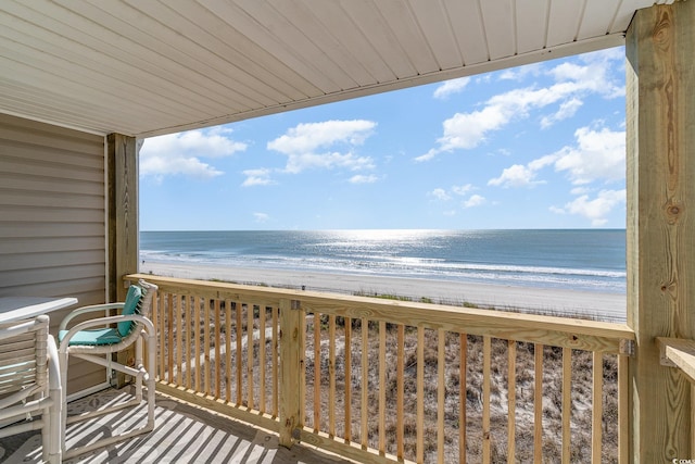 balcony featuring a water view and a beach view