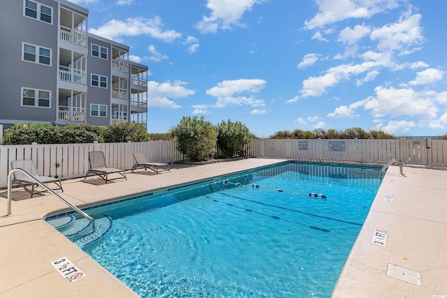pool featuring fence and a patio