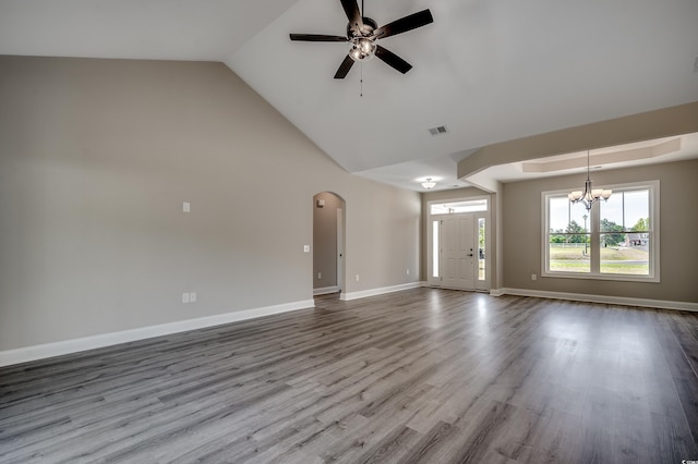unfurnished living room with a chandelier, ceiling fan, dark wood-type flooring, arched walkways, and baseboards