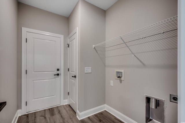 clothes washing area with hookup for an electric dryer, wood finished floors, washer hookup, and baseboards