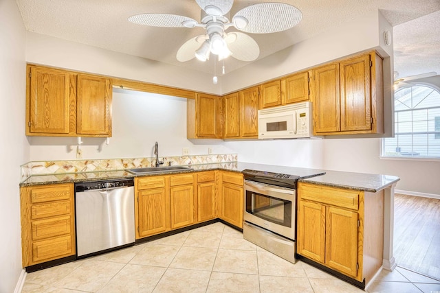 1161 Ganton Way, Myrtle Beach, SC 29588 - kitchen featuring stainless steel appliances, a sink, brown cabinets, a ceiling fan, and a textured ceiling