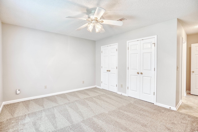 1161 Ganton Way, Myrtle Beach, SC 29588 - unfurnished bedroom with multiple closets, light carpet, a textured ceiling, baseboards, and ceiling fan