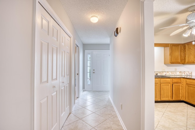 1161 Ganton Way, Myrtle Beach, SC 29588 - hallway featuring a textured ceiling, light tile patterned floors, baseboards, and a sink