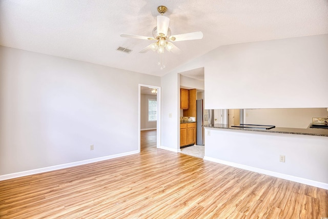 1161 Ganton Way, Myrtle Beach, SC 29588 - unfurnished living room featuring light wood-type flooring, a ceiling fan, baseboards, vaulted ceiling, and a textured ceiling