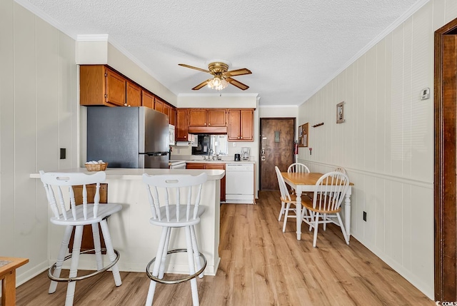 9620 Shore Dr Unit 105, Myrtle Beach, SC 29572 - kitchen featuring white appliances, ceiling fan, a peninsula, light wood-style flooring, and crown molding
