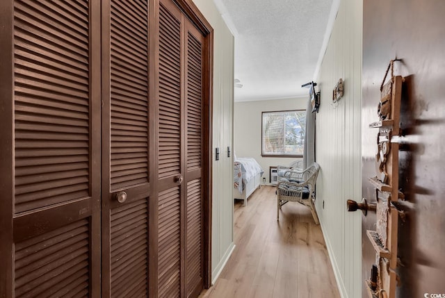 9620 Shore Dr Unit 105, Myrtle Beach, SC 29572 - hallway with light wood-type flooring, crown molding, and a textured ceiling