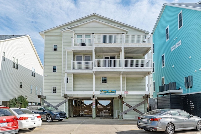 raised beach house featuring uncovered parking and a balcony