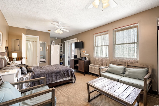 bedroom with freestanding refrigerator, a textured ceiling, and light carpet