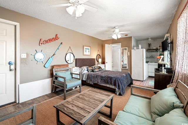 bedroom with freestanding refrigerator, a ceiling fan, a textured ceiling, and light wood finished floors