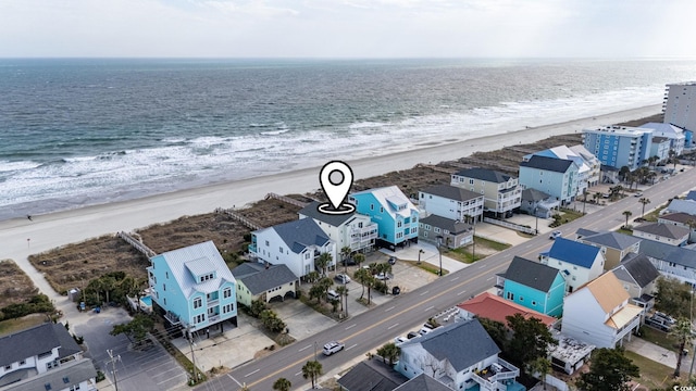 birds eye view of property with a beach view and a water view