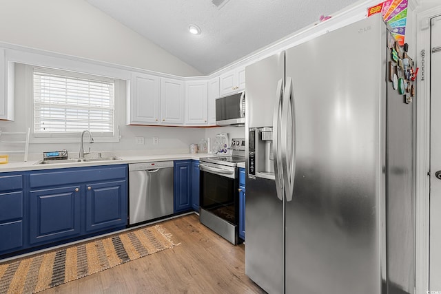 445 Saint Charles Cir, Myrtle Beach, SC 29588 - kitchen with stainless steel appliances, a sink, blue cabinets, vaulted ceiling, and light wood finished floors
