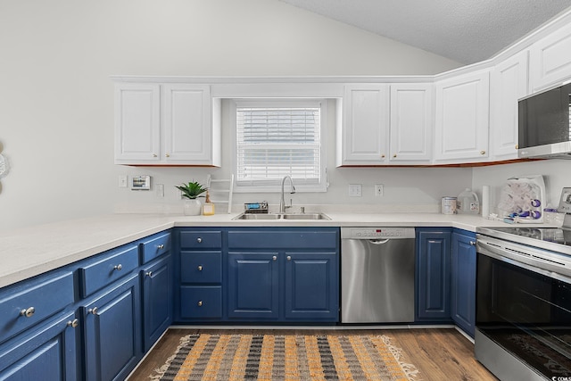 445 Saint Charles Cir, Myrtle Beach, SC 29588 - kitchen with appliances with stainless steel finishes, a sink, blue cabinets, vaulted ceiling, and white cabinetry