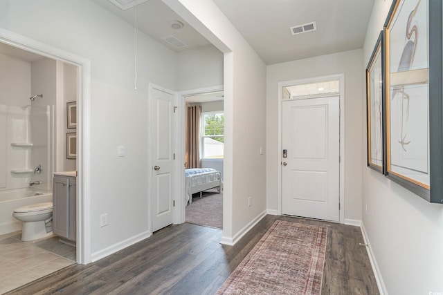 corridor with dark wood-style flooring, baseboards, and attic access